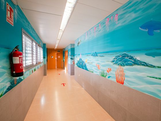 Pasillo decorado con un mural del fondo del mar