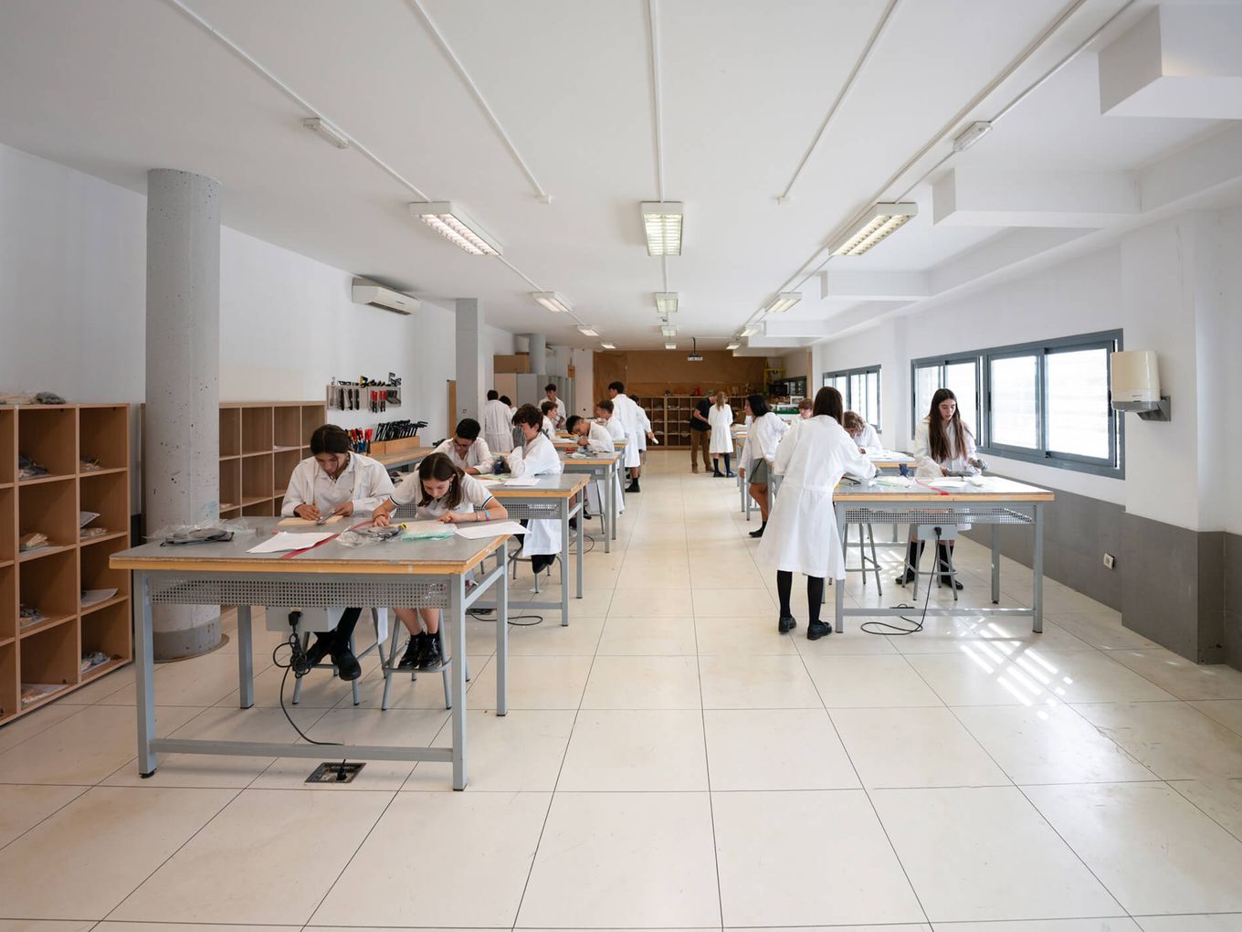 Aula taller con el alumnado trabajando en mesas largas