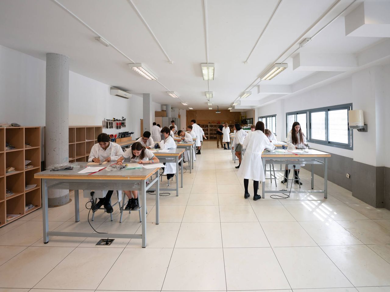 Aula taller con el alumnado trabajando en mesas largas