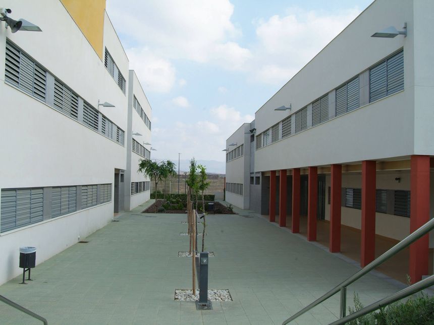 Patio entre dos edificios blancos del colegio