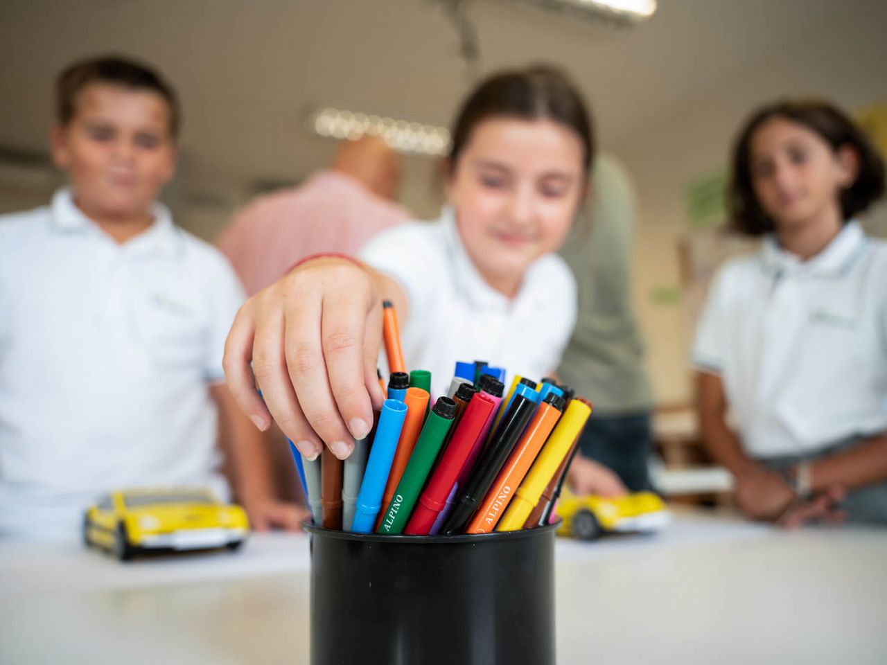 Tres alumnos de Primary eligen rotuladores en clase