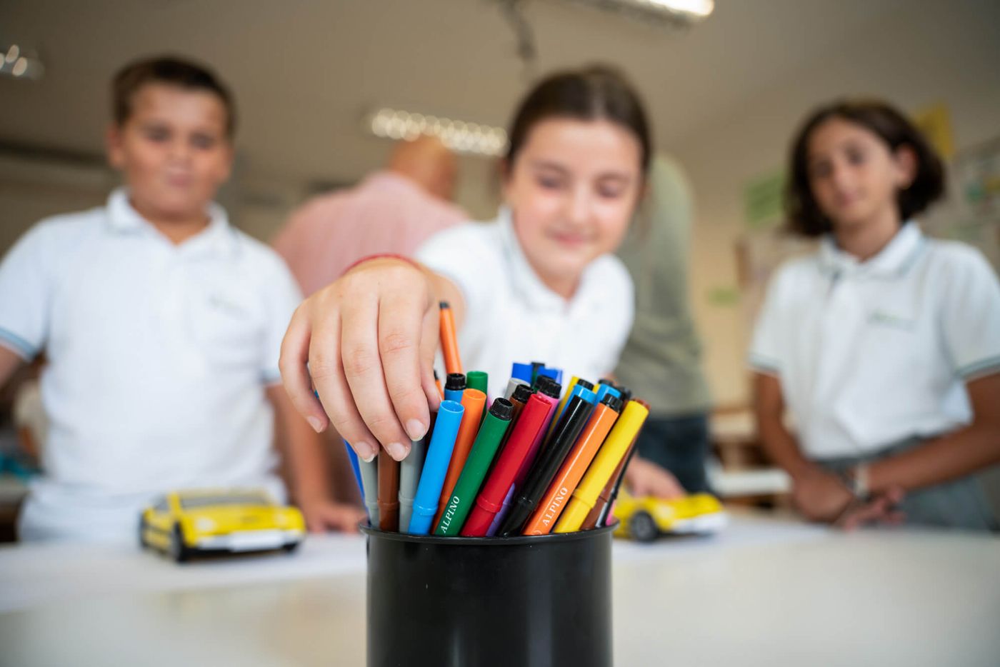 Tres alumnos de Primary eligen rotuladores en clase