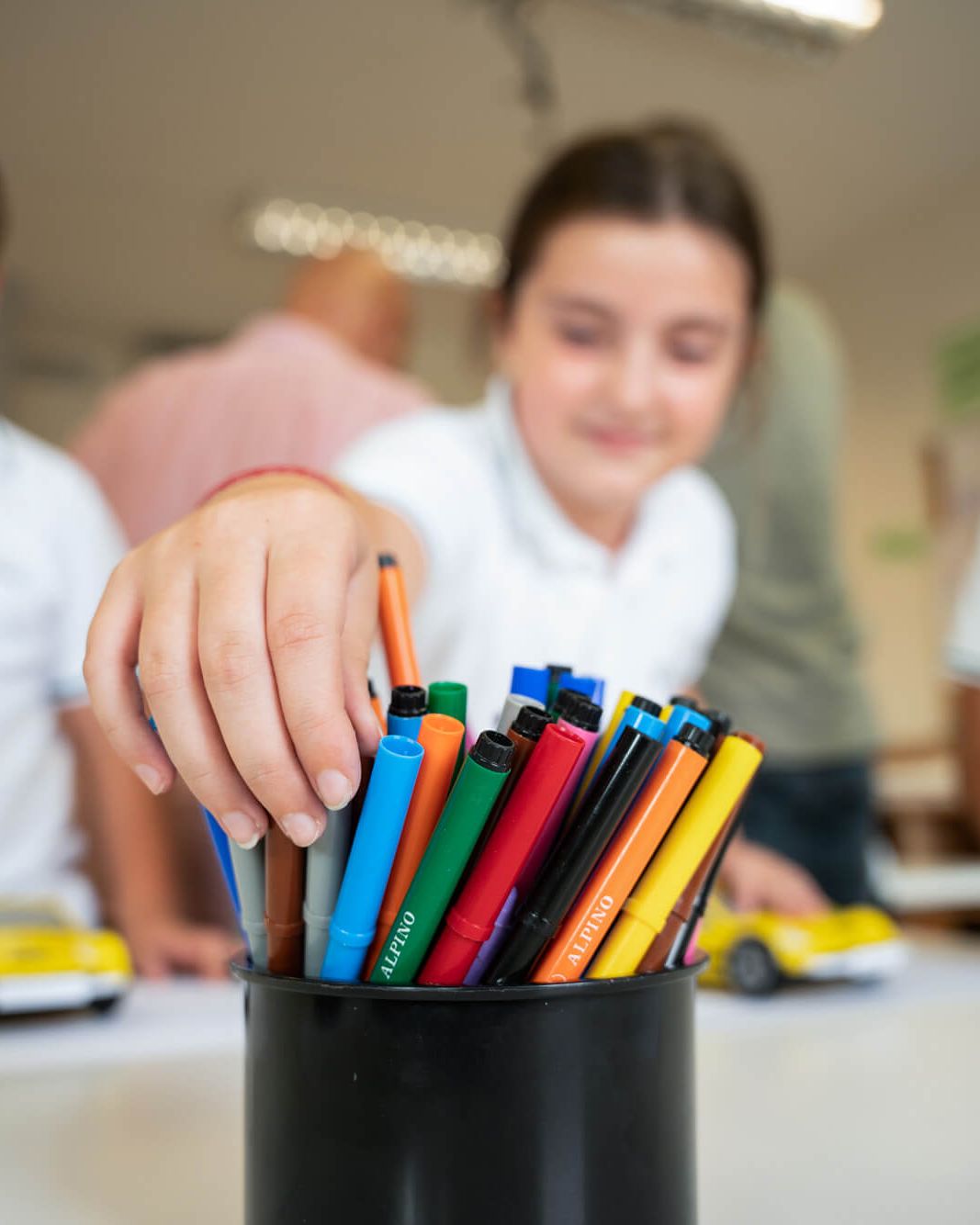 Tres alumnos de Primary eligen rotuladores en clase
